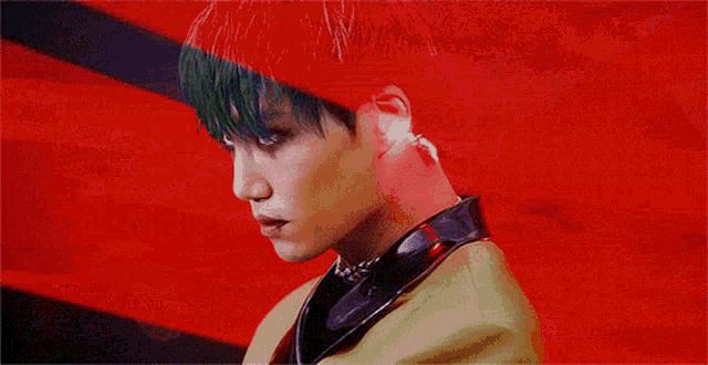 a close up of a person 's face with green hair and a yellow jacket .