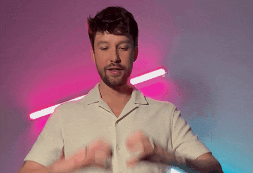 a man in a white shirt is making a heart with his hands
