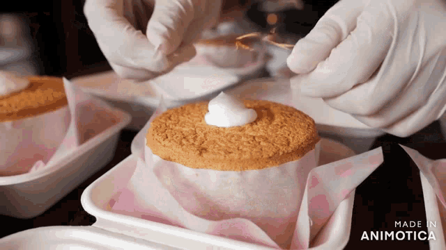 a person is decorating a cake with whipped cream and the words made in animotica