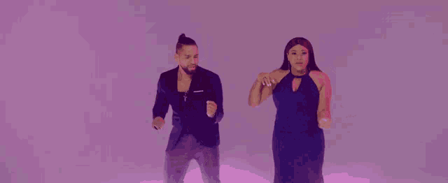 a man in a suit and a woman in a dress are standing next to each other
