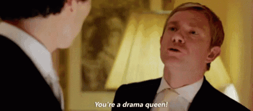 a man in a suit and tie is talking to another man and saying `` you 're a drama queen ! ''