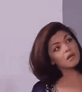 a close up of a woman making a funny face while looking at the camera .