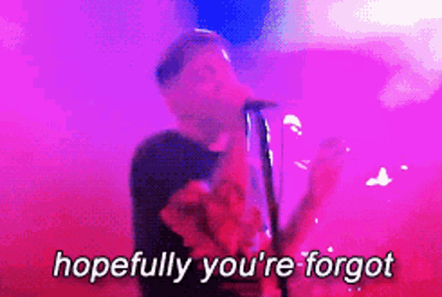 a man singing into a microphone with the words hopefully you 're forgot written below him