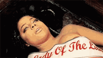 a woman is laying in a coffin wearing a white top that says lady of the lake