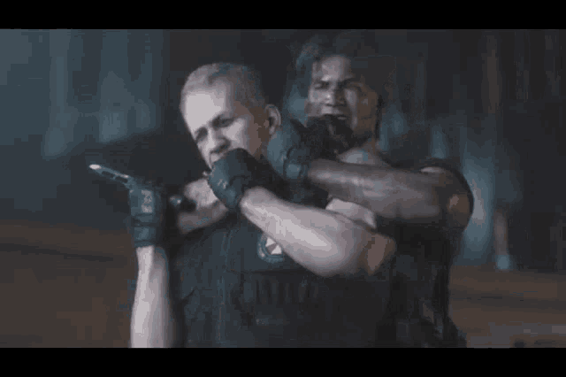 two soldiers are walking in front of a van and one is holding a gun