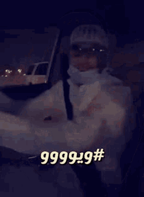 a man wearing glasses and a mask is sitting in a car with his hands up .
