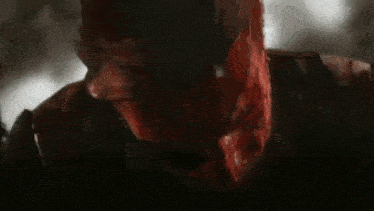 a close up of a man covered in blood with his mouth open .