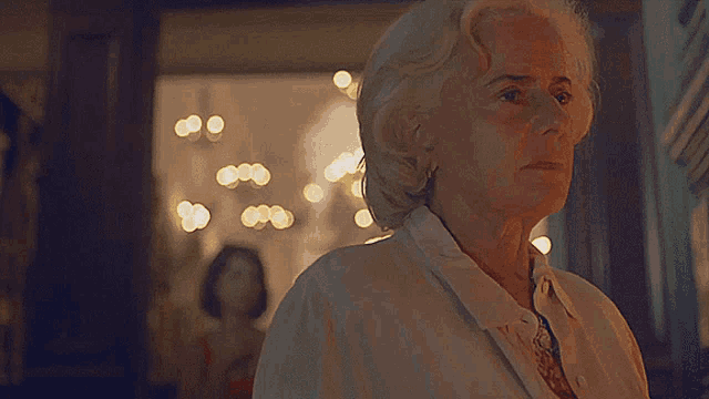 a woman with white hair is standing in front of a doorway