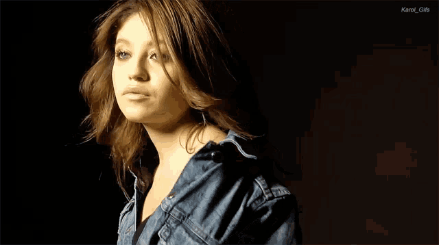 a woman in a denim jacket is looking at the camera with the words kanel gifs below her