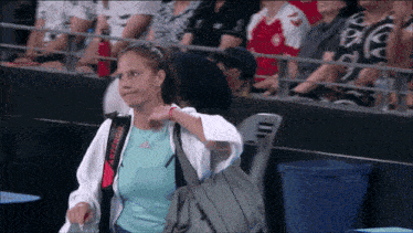 a woman wearing a white jacket with the word artengo on the back