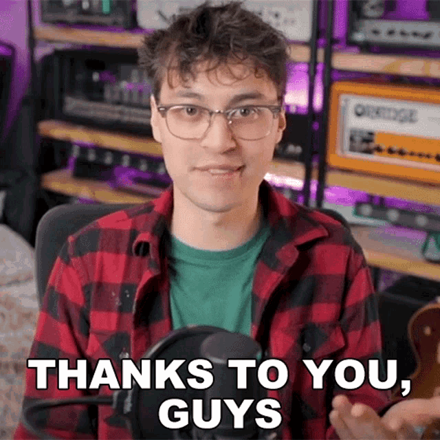 a man wearing glasses and a plaid shirt says " thanks to you guys "