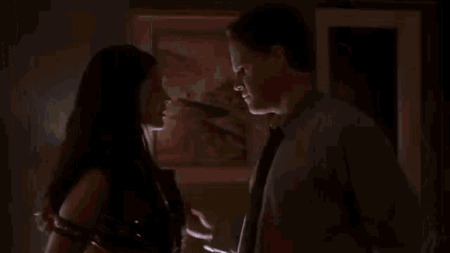 a man and a woman are praying together in a dark room .