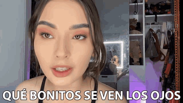 a woman says " qué bonitos se ven los ojos " in front of a closet full of clothes