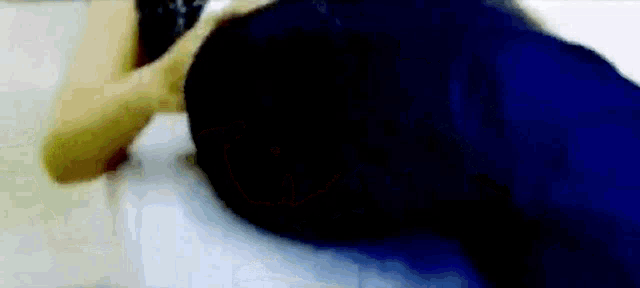 a blurry picture of a person laying on a bed with their back to the camera .