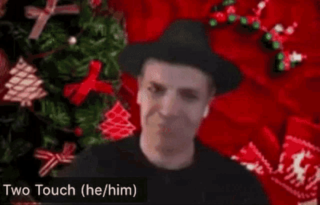a person is making a heart shape with their hands and a christmas tree in the background .