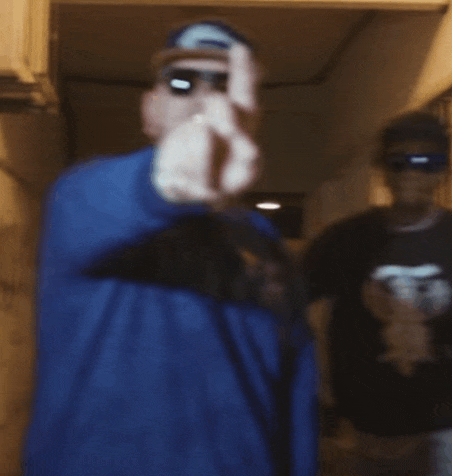 a blurry photo of a man wearing sunglasses and a blue shirt