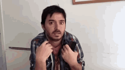 a man with a beard is holding a cell phone in his hands .