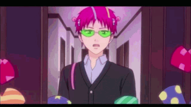 a boy with pink hair and green glasses is walking down a hallway .