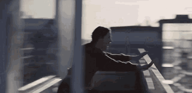 a man is leaning over a railing on a balcony .