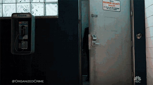 a phone booth next to a door that says maximum security facility on it