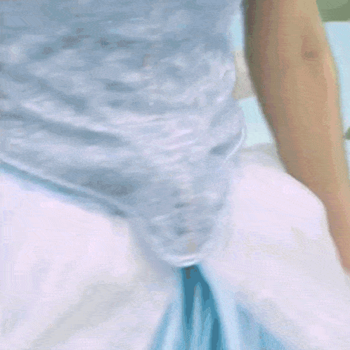 a woman in a blue dress is standing in front of a washing machine