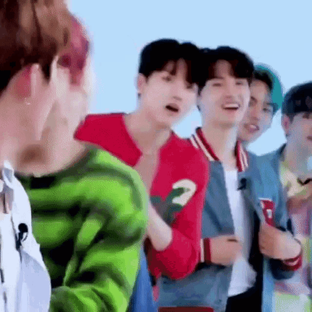 a group of young men are standing next to each other and talking .