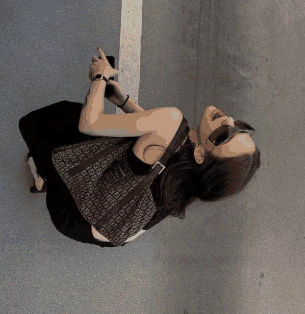 a woman wearing sunglasses and a vest with fendi on it