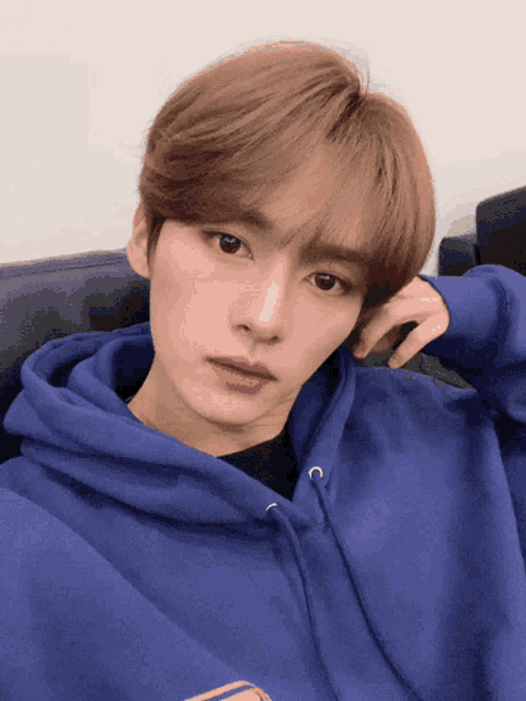 a young man wearing a blue hoodie with the letter c on the front