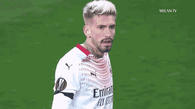 a soccer player is wearing a white emirates jersey