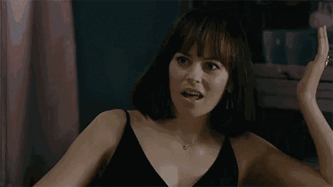 a woman in a black bra is making a funny face and says he 's fucking her .