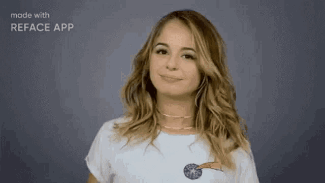 a woman in a white t-shirt is smiling and making a peace sign .