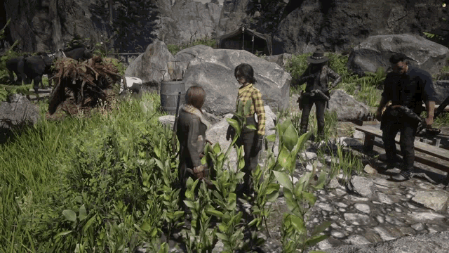 a group of people are standing in a grassy area with a man holding a camera