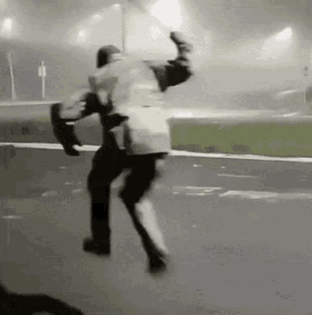 a man is jumping in the air while riding a skateboard on a street at night .