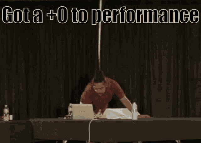 a man sits at a table with a laptop and the words got a +0 to performance natural 2