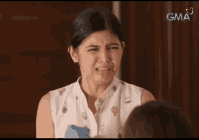 a woman is making a face in front of a gma logo