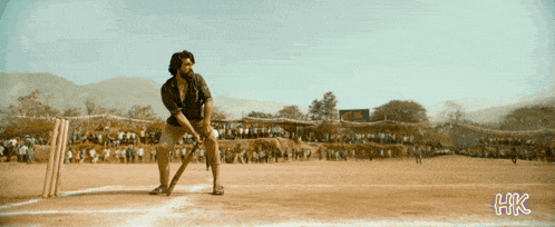 a man is swinging a bat on a cricket field with hkc written on the bottom right