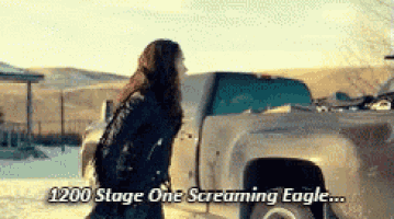 a woman standing in front of a truck that says 1200 stage one screaming eagle ..