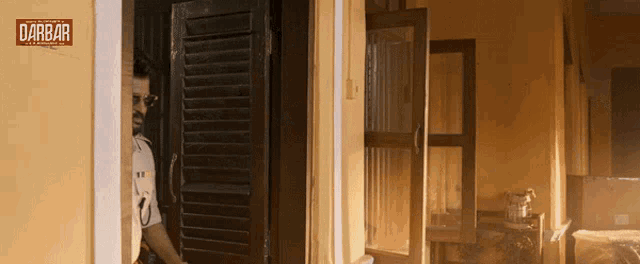 a man standing in a doorway with the word darbar on it