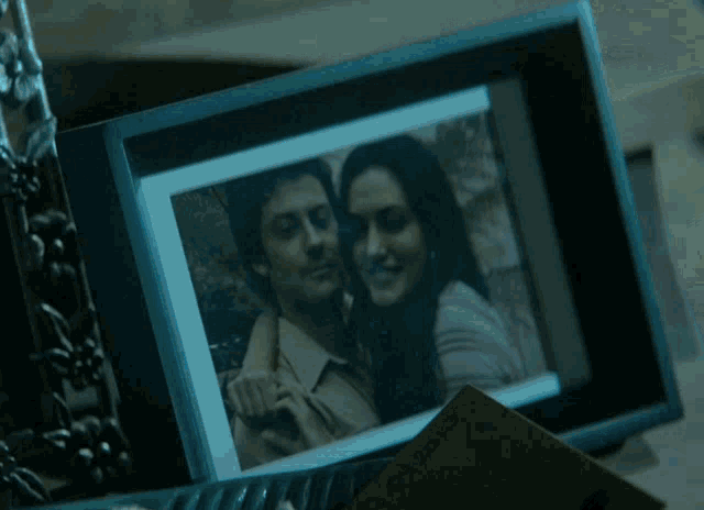 a framed picture of a man and a woman is sitting next to a card that says california