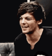 a close up of a man making a funny face while sitting on a couch .