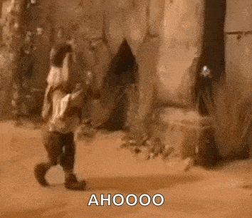 a teddy bear is walking down a dirt road in front of a wall .