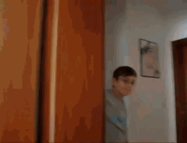 a young boy is standing in a doorway .