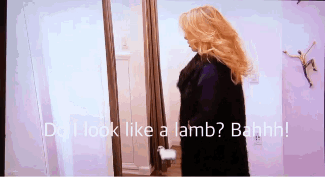 a woman is standing in front of a mirror with the words do i look like a lamb bahhh