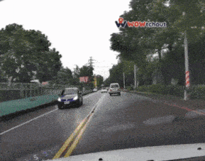 a car is driving down a road with a wow tchout logo on the bottom