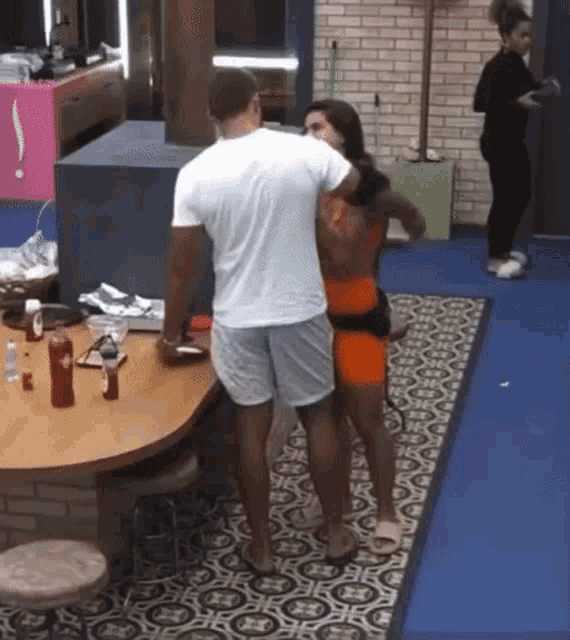 a man and woman are standing next to each other in a kitchen .