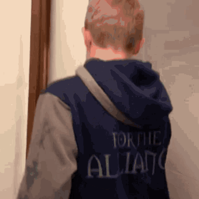 a boy wearing a blue hoodie that says torthe alliance