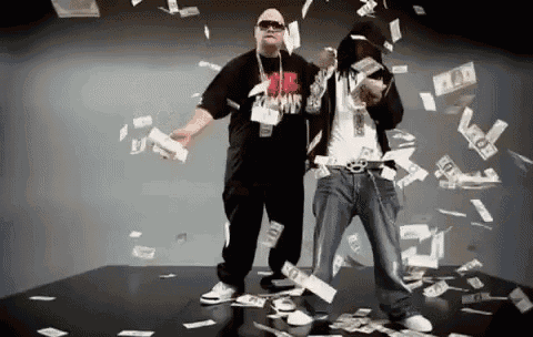 two men are dancing in front of a lot of money falling from the sky .