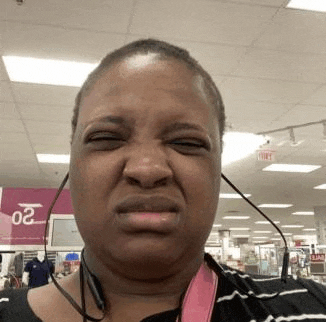 a woman wearing headphones is making a funny face while standing in a store .