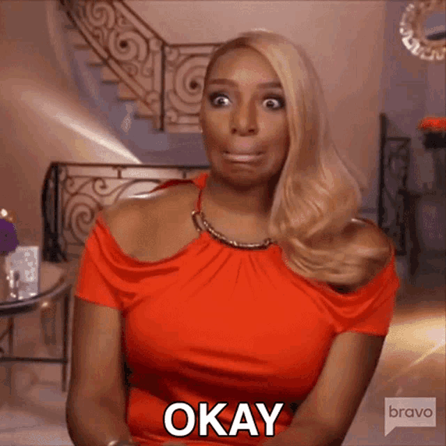 a woman in a red dress is making a funny face and saying okay