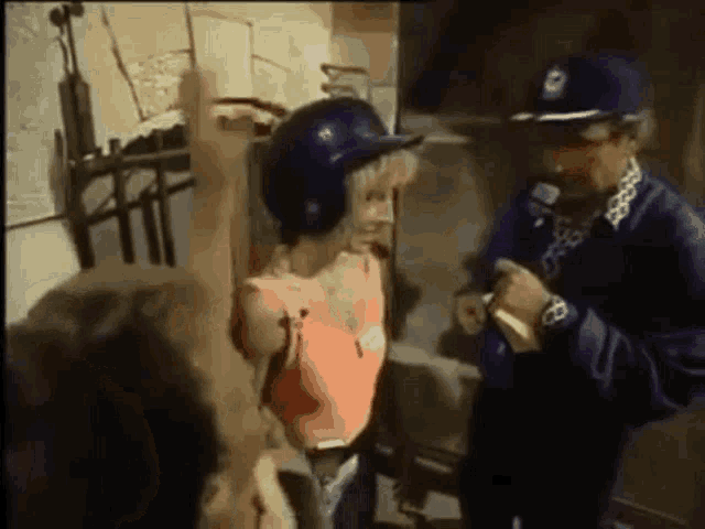 a woman wearing a blue helmet is standing next to a police officer .